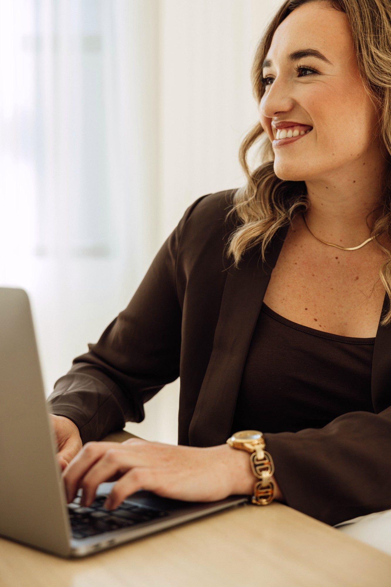 Kristin Pitts at her laptop, smiling as she looks across the room